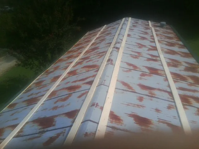 Rusted metal roof panels with new wood purlins before replacement — Storm Damage Roof Repair in Blooming Grove by Roofing Brothers
